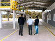 Na foto estão 3 homens de costas, sendo, da esquerda para a direita, o presidente do IPEM/PR, Dr. Cesar Mello, Shiniti Honda, diretor de metrologia e qualidade e Michel A. Ravazi, gerente da regional de Maringá.