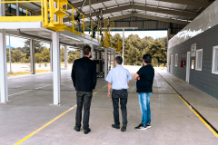 Na foto estão 3 homens de costas, sendo, da esquerda para a direita, o presidente do IPEM/PR, Dr. Cesar Mello, Shiniti Honda, diretor de metrologia e qualidade e Michel A. Ravazi, gerente da regional de Maringá.