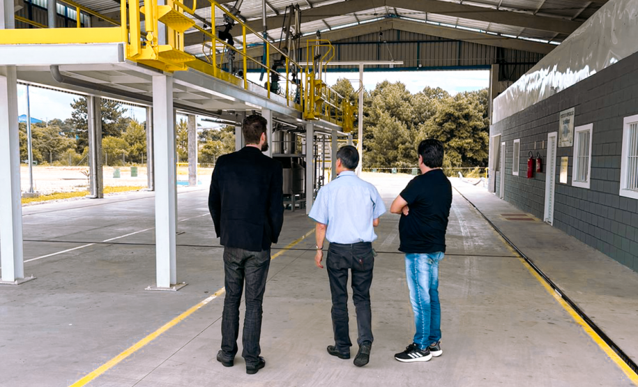 Na foto estão 3 homens de costas, sendo, da esquerda para a direita, o presidente do IPEM/PR, Dr. Cesar Mello, Shiniti Honda, diretor de metrologia e qualidade e Michel A. Ravazi, gerente da regional de Maringá.